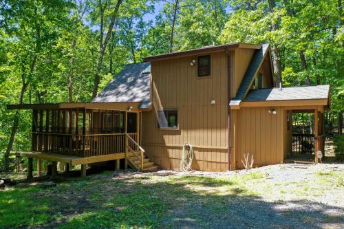 a tiny house in the woods with a porch at Dog-Friendly A-Frame with Firepit and Fall Foliage in Hedgesville