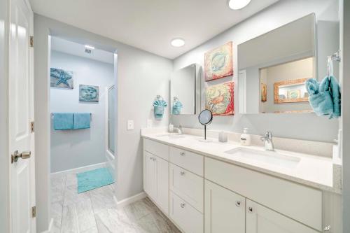 a bathroom with two sinks and a large mirror at Dolphin Days Lagoon Retreat in Panama City Beach