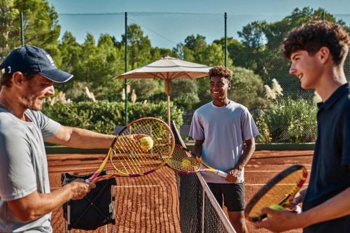 a group of men holding tennis rackets on a court at Ikos Aria in Kefalos