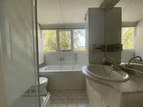 a bathroom with a tub and a sink and a toilet at Hello Zeeland - Vakantiehuis Zwin 092 in Breskens