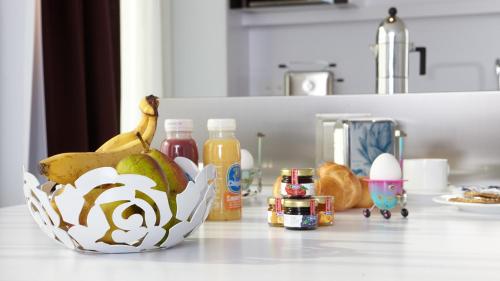 a counter top with a bowl of bananas and other food at City Apartments in Zug