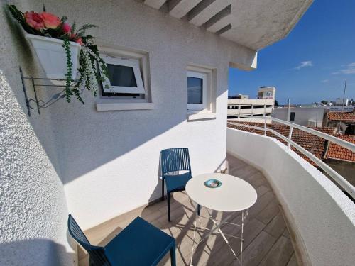 a balcony with a table and chairs on a building at Kitieos Central Apts 100m from Finikoudes Beach in Larnaca