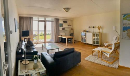 a living room with a couch and a table at Hello Zeeland - Appartement Port Scaldis 19-012 in Breskens
