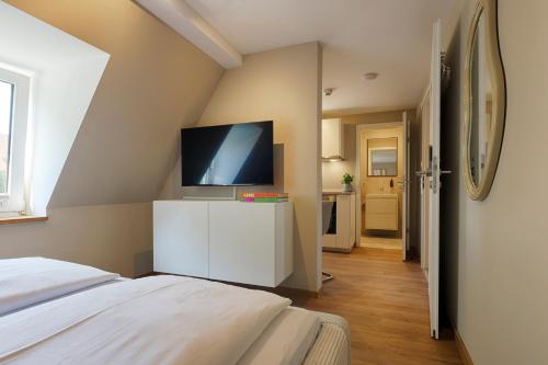 a bedroom with a bed and a flat screen tv at Hotel Fischzucht in Würzburg in Würzburg