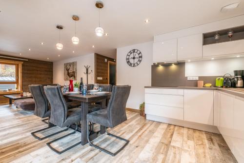 une cuisine et une salle à manger avec une table et des chaises dans l'établissement FLOCON Appartement 3 chambres, centre de Morzine, à Morzine