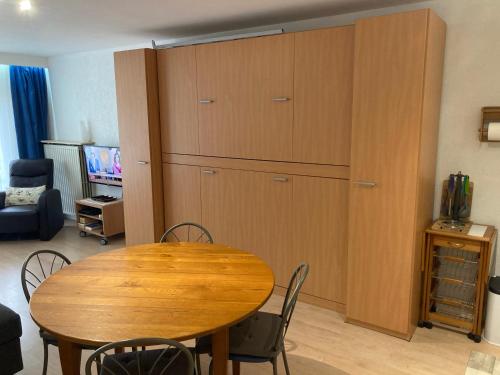 a dining room with a table and a large cabinet at My Fair - Koksijde in Koksijde