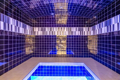 - une salle de bains carrelée de bleu avec une piscine dans l'établissement FLOCON Appartement 3 chambres, centre de Morzine, à Morzine