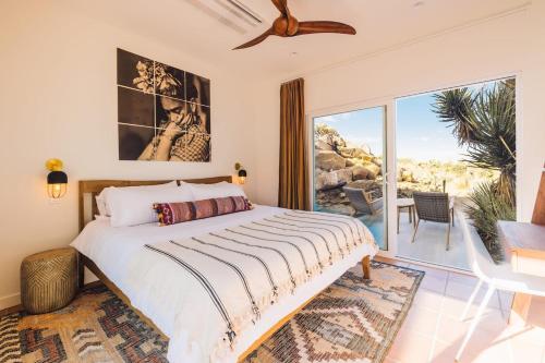 a bedroom with a bed and a large window at Bolder House By The Cohost Company in Joshua Tree