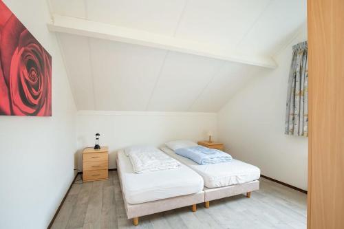 a bedroom with two beds and a painting on the wall at Hello Zeeland - Vakantiehuis Schelde 194 in Breskens