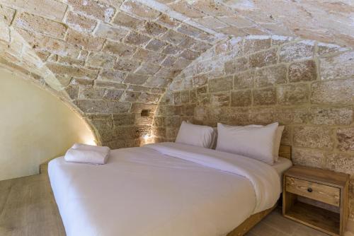 a bedroom with a bed in a brick wall at Casa Batroun Lofts in Batroûn
