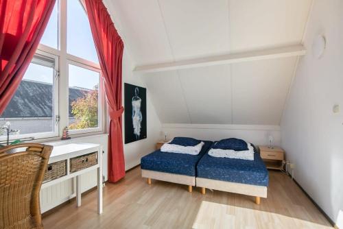 a bedroom with a bed and a window at Hello Zeeland - Vakantiehuis Zwin 004 in Breskens
