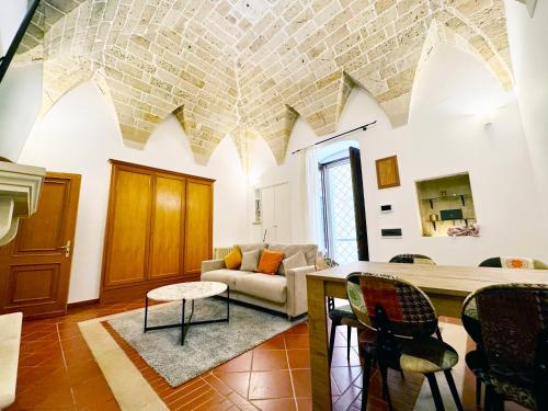 een woonkamer met een bank en een tafel bij Casa Ginevra, private Parking in Lecce
