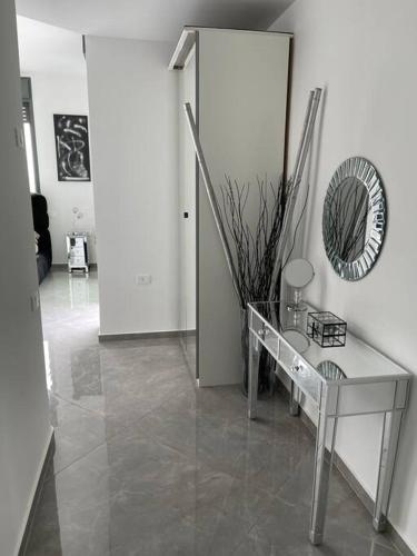 a living room with a glass table and a mirror at Penthouse Netanya in Udim