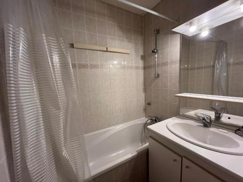 une salle de bain avec un lavabo et un rideau de douche dans l'établissement Appartement fonctionnel, 3 pièces, balcon, 7 personnes, animaux admis - FR-1-181-2420, à La Plagne Tarentaise