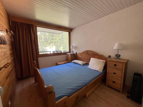 une chambre avec un lit en bois et une fenêtre dans l'établissement Appartement fonctionnel, 3 pièces, balcon, 7 personnes, animaux admis - FR-1-181-2420, à La Plagne Tarentaise