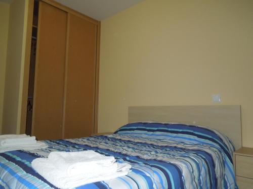 1 dormitorio con 1 cama con toallas en Apartamento Cuatro Torres, en Madrid