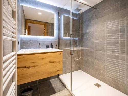 une salle de bain avec une douche, un lavabo et un miroir dans l'établissement Appartement Neuf 4* Méribel-Mottaret - 85m², 6 pers, Balcon, Jardin, Garage - Proche Pistes et Commerces - FR-1-355-212, à Les Allues