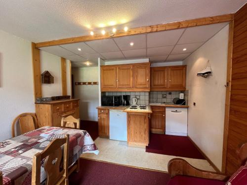 - une cuisine avec des placards en bois et une table dans une pièce dans l'établissement Spacieux appartement 3 pièces pour 8 personnes avec balcon, centre station - FR-1-181-2113, à La Plagne Tarentaise