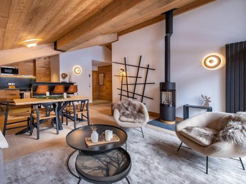 un salon avec une table et des chaises et une cheminée dans l'établissement Appartement avec balcon, poêle à bois, parking - 6 pers. - FR-1-355-213, à Les Allues