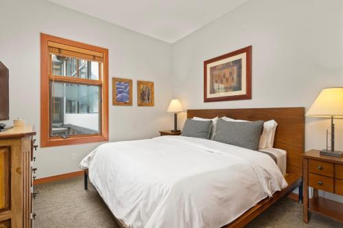 a bedroom with a large white bed and a window at Foxtail Flat Capitol Peak's Coziest Corner Unit in Snowmass Village