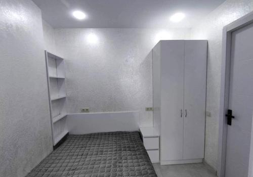 a white room with a bed and a closet at Orbi Apartment near sea in Angisa