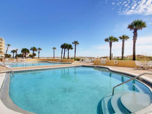 a swimming pool at a resort with palm trees at Emerald Isle #401 in Pensacola Beach