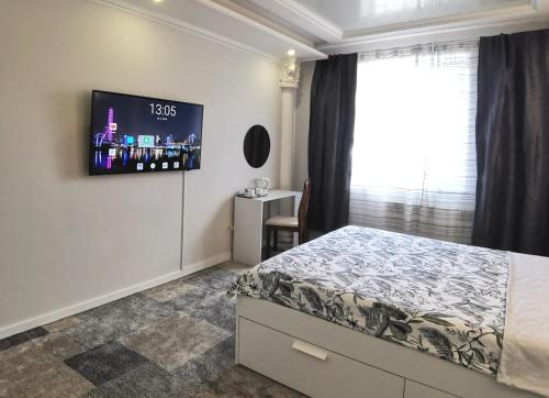 a bedroom with a bed and a tv on the wall at Приватний будинок в Миколаєві з гаражем Private House in Mykolaiv with garage in Mykolaiv