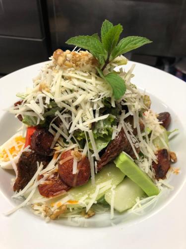 a white plate of food with a salad on it at Lisas Gästehaus in Neckartenzlingen