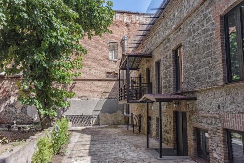 un callejón en un antiguo edificio de ladrillo con balcón en ARAKI Sololaki, en Tiflis