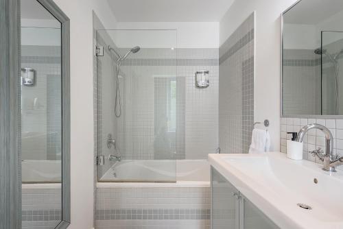 a white bathroom with a tub and a sink at Loft The White Pearl Plateau-Mont-Royal 3 Beds in Montréal