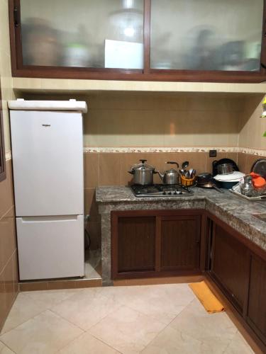 Una cocina con estufa y refrigerador blanco. en Mahmoud Moulay Yacoub, en Moulay Yacoub