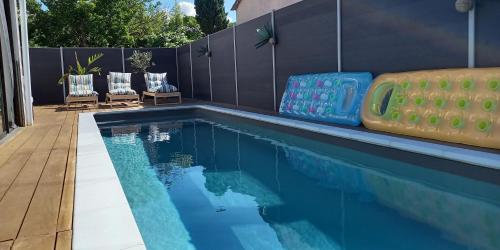 une piscine avec deux chaises longues et une piscine dans l'établissement Villa Vacances avec piscine Côte d'Azur, à La Londe-les-Maures