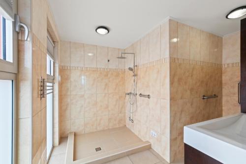 un baño con ducha y lavabo en Heerlijk appartement met prachtig uitzicht op zee!, en Jan Thiel