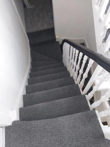 a staircase in a house with black and white at Rivers in Bromley