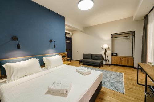 Un dormitorio con una cama grande con una pared azul. en ARAKI Sololaki, en Tiflis