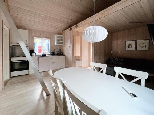 eine Küche und ein Esszimmer mit einem weißen Tisch und Stühlen in der Unterkunft Discover This Well-appointed Cottage Cottage D in Vágur