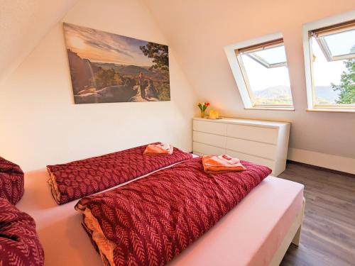 a bedroom with a bed with a red comforter at Urlaubsmagie - Ferienwohnung Biberburg - mit Balkon - B7 in Lichtenhain