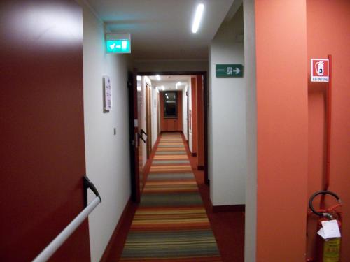 a hallway with orange walls and a long corridor at Hotel Rioverde in Pralormo