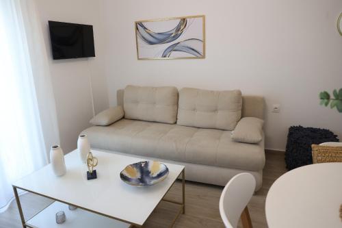 a living room with a couch and a table at Iliana's apartment in Kardítsa