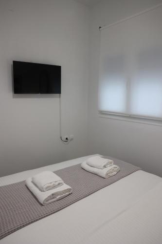 two towels on a bed with a flat screen tv at Iliana's apartment in Kardítsa