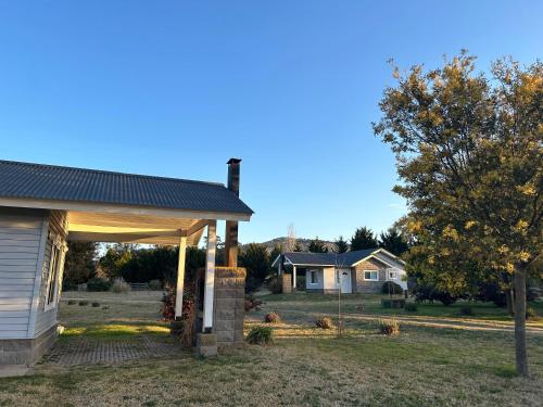 a house with a covered porch in a yard at Edén Soñado in Tandil