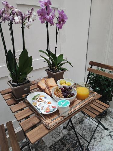 een ontbijtblad met ontbijtproducten op een tafel met bloemen bij Suite Gimma 209 in Bari