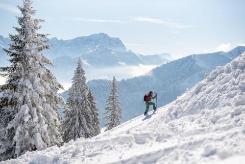 a person is skiing down a snow covered mountain at AURA-HOTEL Saulgrub in Saulgrub