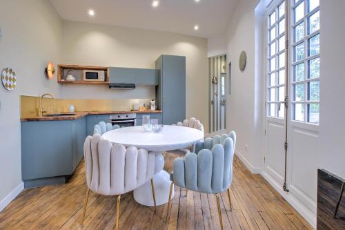 une cuisine et une salle à manger avec une table et des chaises blanches dans l'établissement Chez Jeannette, à Périgueux