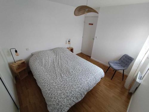 une chambre avec un lit et une chaise bleue dans l'établissement Appartement proche de la mer à Pléneuf-Val-André, à Pléneuf-Val-André