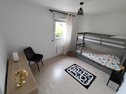 une chambre avec un lit, une table et une chaise dans l'établissement Appartement proche de la mer à Pléneuf-Val-André, à Pléneuf-Val-André