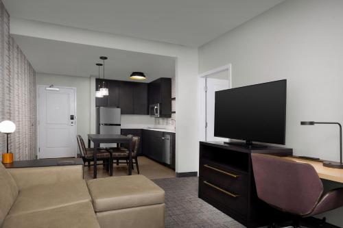 a living room with a couch and a flat screen tv at Residence Inn by Marriott Indianapolis Plainfield in Plainfield