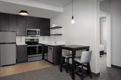 a kitchen with a table and chairs in a room at Residence Inn by Marriott Indianapolis Plainfield in Plainfield