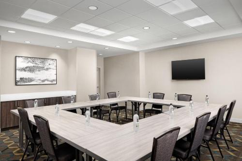 a conference room with tables and chairs and a flat screen tv at Residence Inn by Marriott Indianapolis Plainfield in Plainfield