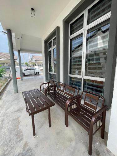 two wooden benches sitting outside of a building at Homestay faleeq in Jerantut